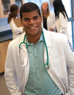 male health care professional wearing a white coat, button up green shirt, and a stethoscope look...